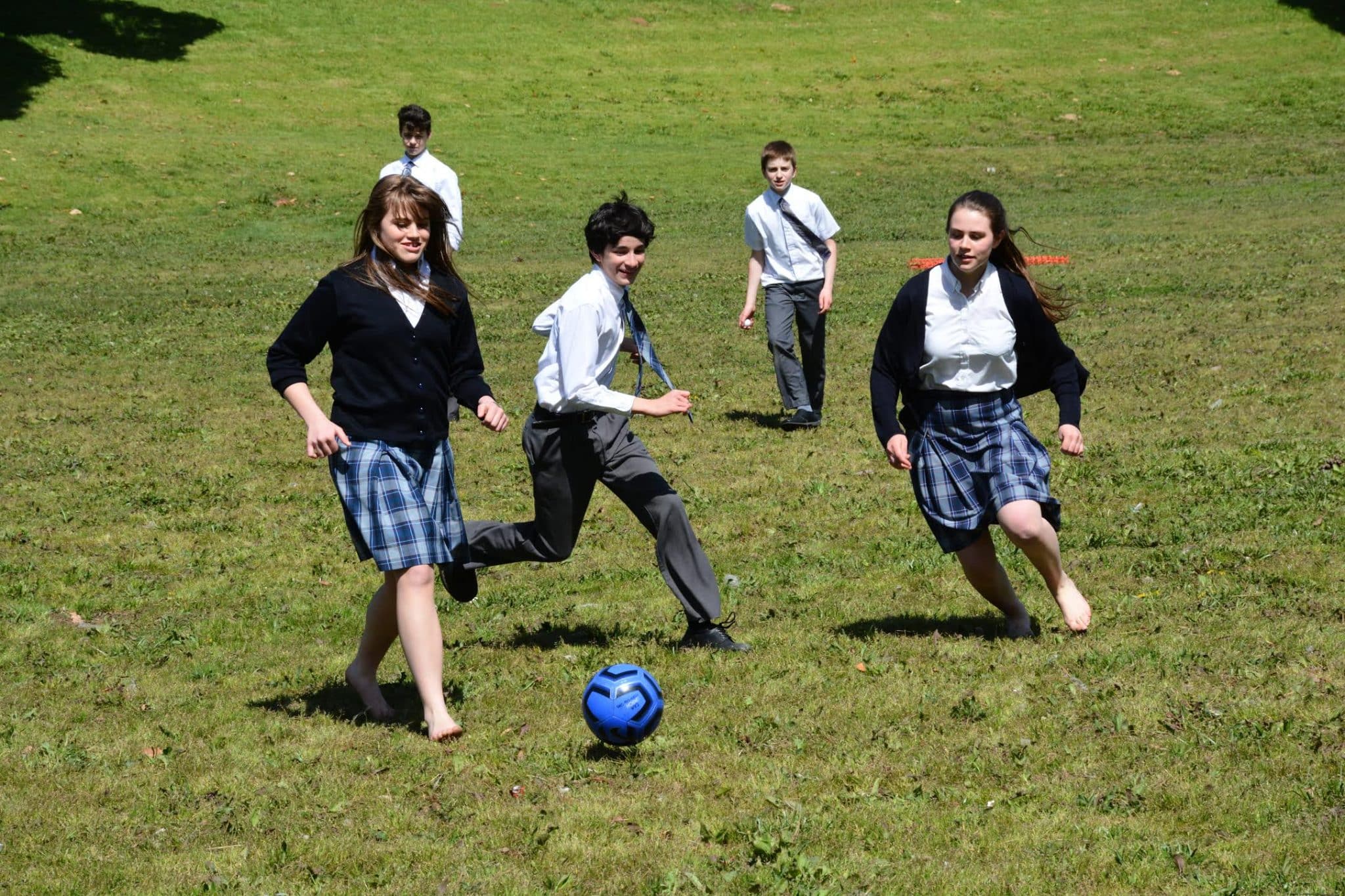 st. andrew's academy students playing soccer in green field